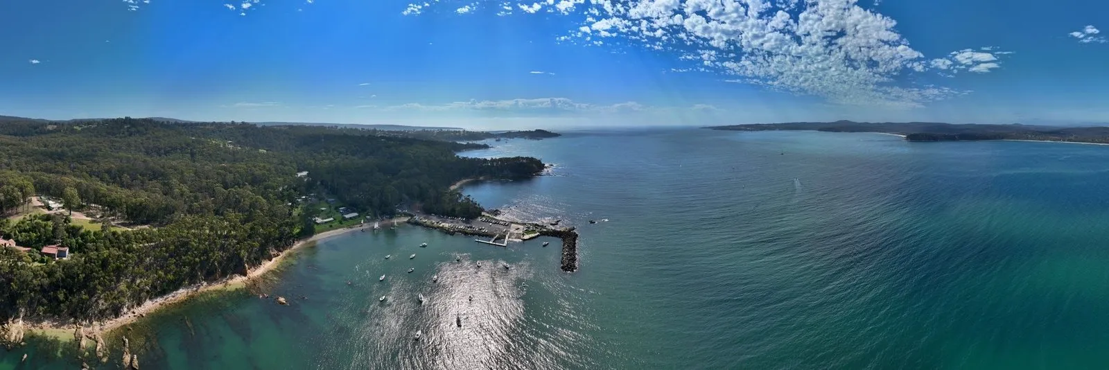 Quarantine Bay on regatta day, with boats moored by the breakwater and Twofold Bay stretching away